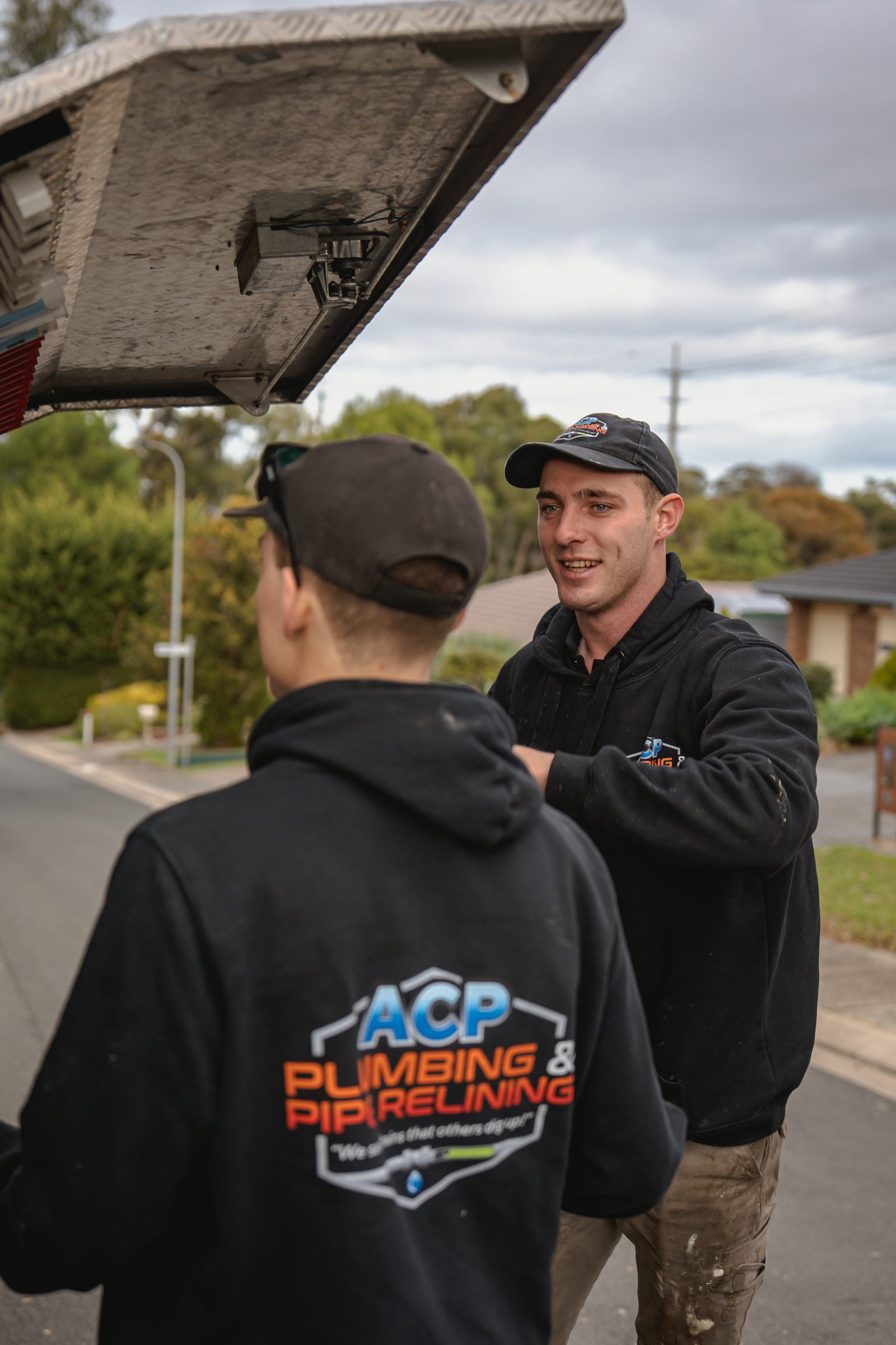 Two ACP plumbers at the truck
